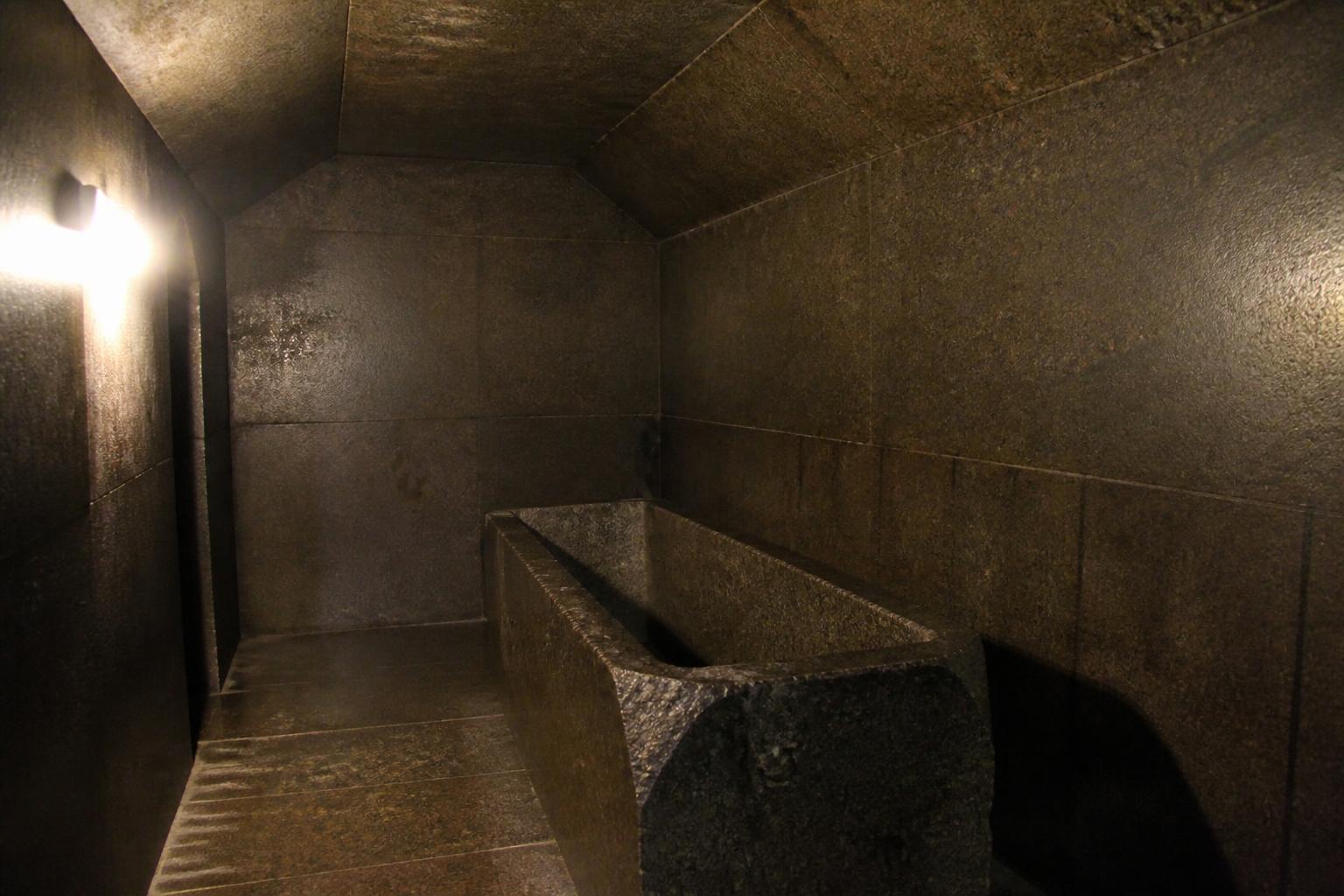 Dark granite pyramid chamber with a human figure and subtle sound-wave lines illustrating acoustic resonance.